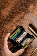 A hand holding an open Mehroon leather zip-around wallet with multiple card slots and cash compartments Pakistan