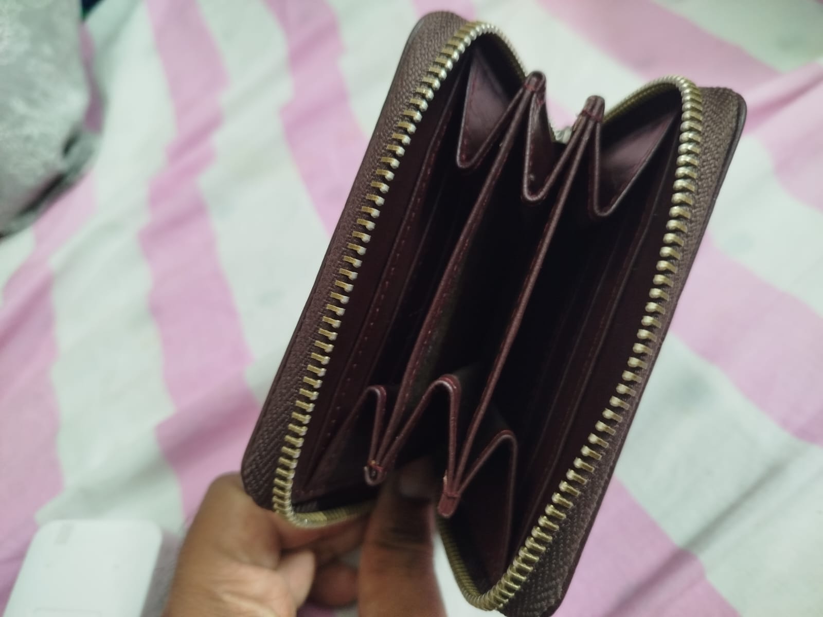 Women's Mehroon textured Genuine leather zip-around wallet held open by a hand, showing multiple card slots Made in Pakistan 